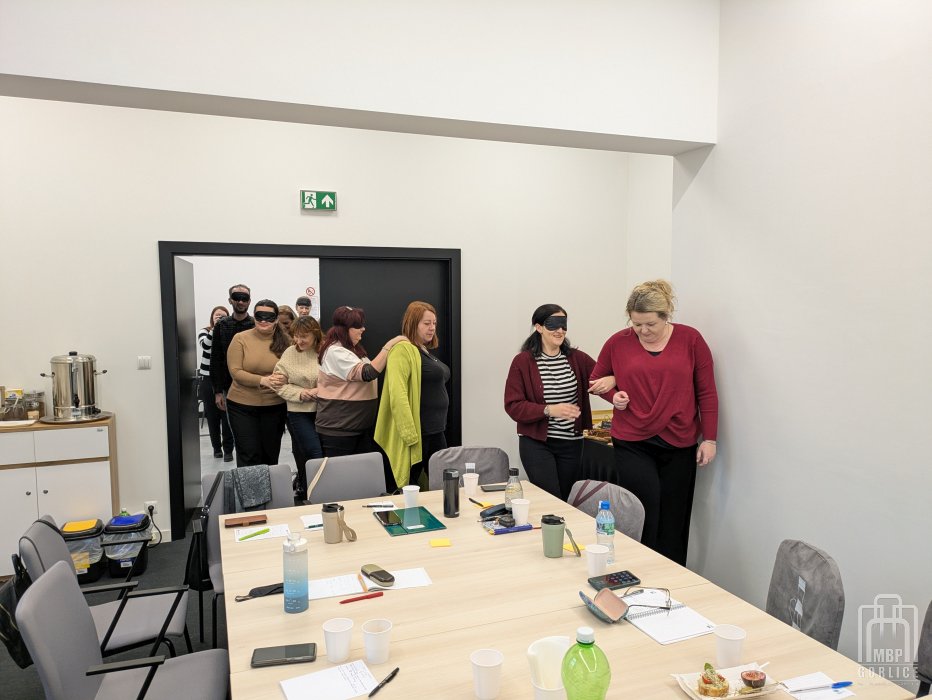 Biblioteka Gorlice, Szkolenie o odstępności ćwiczenie - bibliotekarze wchodzą do sali parami, co druga osoba ma zasłonięte oczy